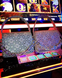 two purses on a table in front of a slot machine